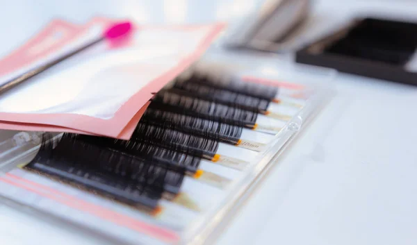 Beyaz masada takma kirpik ve kirpik fırçası.