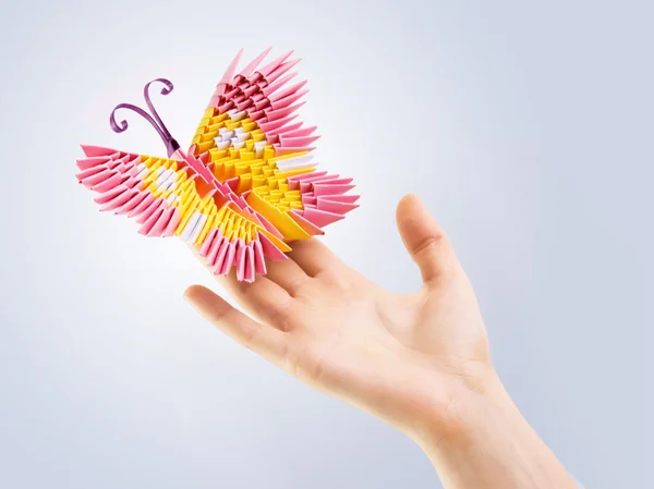 Pink butterfly in a hand — Stock Photo, Image