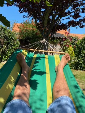 Bahçedeki Wood Line 'da hamakta yatan adam. Rahatlama kavramı.