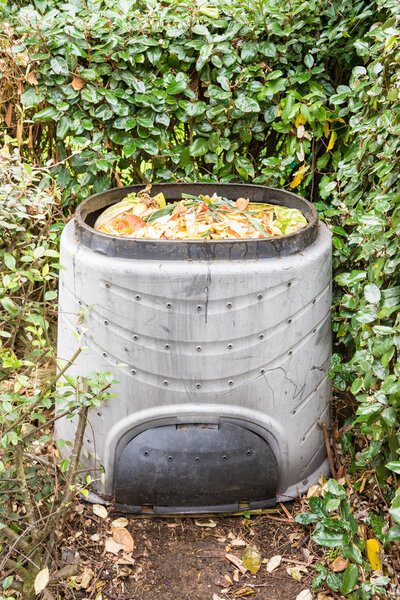 Компостирование отходов кухни в пластиковую корзину для компоста
