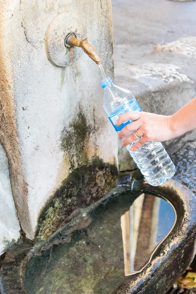 Llenar la botella de agua de una fuente de hidrante — Foto de Stock