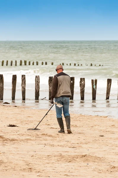 Homme à la recherche d'un métal précieux à l'aide d'un détecteur de métaux — Photo