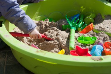 kum havuzunda oynayan çocuk