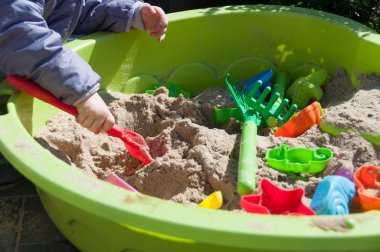 kum havuzunda oynayan çocuk