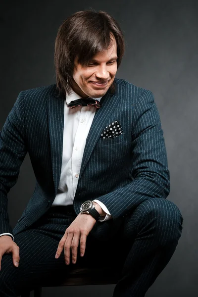 handsome man with long hair brunette and brown eyes in dark suit