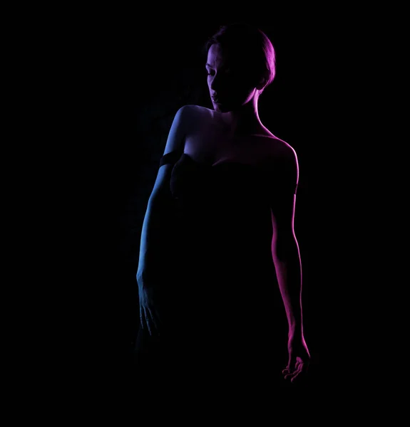 在黑暗的背景上 一个美丽女人的身体轮廓 蓝光和粉色光 — 图库照片