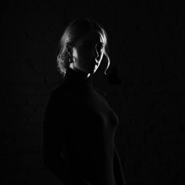 Karanlık bir arka planda güzel bir kadının portresi. Siyah beyaz fotoğraf.