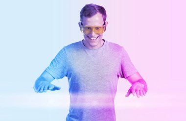 Genç adam online sanal oyun oynuyor, mavi ve pembe siber renkte..