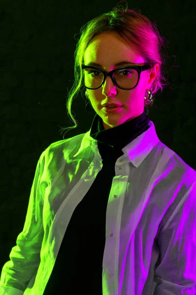 Retrato Mujer Joven Gafas Luz Rosa Verde Sobre Fondo Oscuro — Foto de Stock