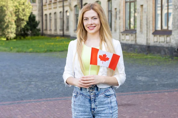 年轻的女学生笑着举着加拿大国旗上大学 加拿大教育 假日加拿大日 — 图库照片