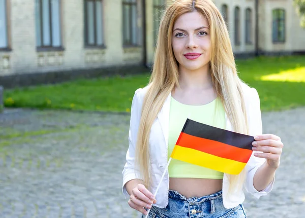 Beautiful young woman with flag of Germany. Learn German