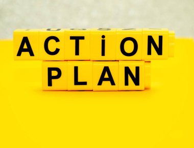 Action plan - words from yellow plastic blocks on the yellow background. Concept life, work and success business. Copy space for your text.