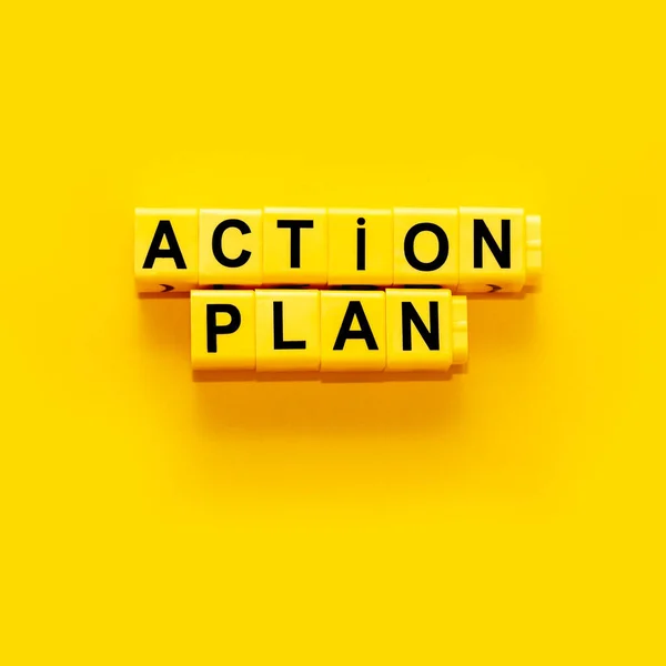 Action plan - words from yellow plastic blocks on the yellow background. Square concept life, work and success business. Copy space for your text.