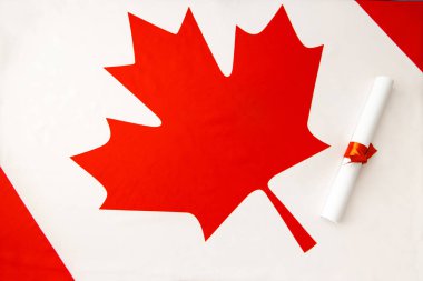 Kanada bayrağının arka planına karşı diploma. Kanada eğitimi. Mezuniyet günü.