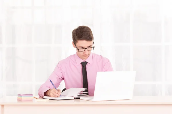 Young male student raised his thumbs up. Business man sitting at his desk, next to a laptop — Stock Photo, Image