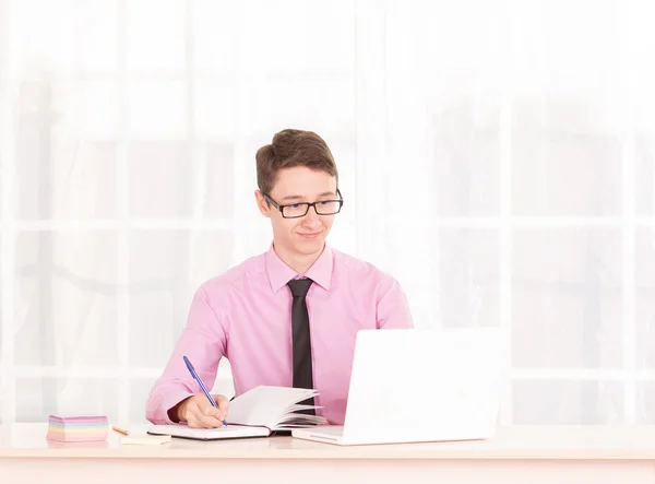 Young male student raised his thumbs up. Business man sitting at his desk, next to a laptop — Stock Photo, Image