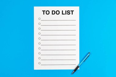 To do list, text and list on a page, and a pen. New resolution concept, top view on a blue background.