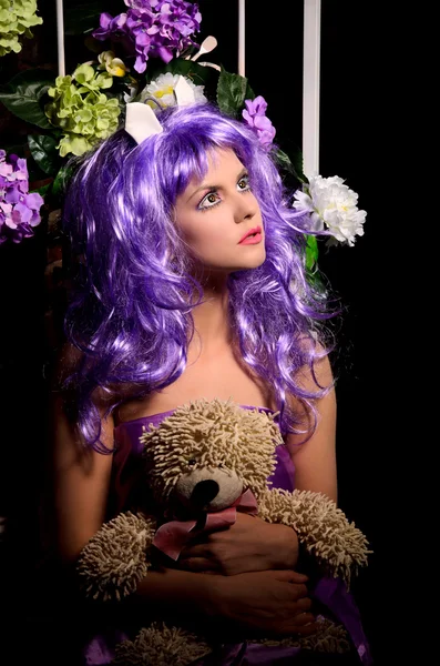 Cosplay-Mädchen in lila Perücke mit Spielzeug und Blumen — Stockfoto