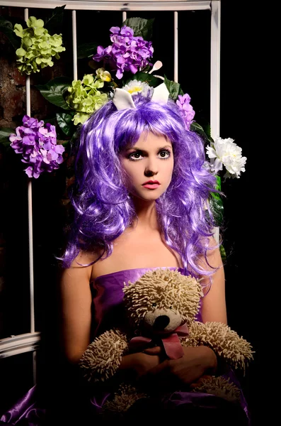 在长满鲜花和玩具的紫色假发 cosplay 女孩 — 图库照片