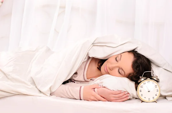 Sleeping young woman and alarm clock — Stock Photo, Image