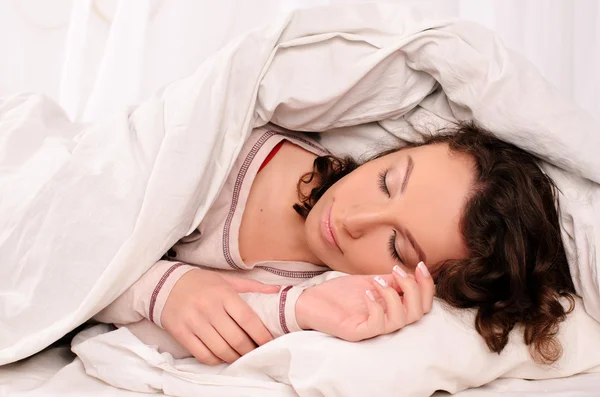 Mulher muito jovem dormindo na cama branca — Fotografia de Stock