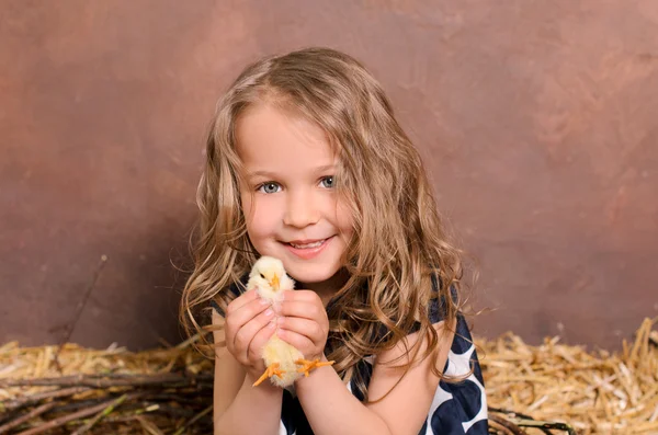 Kleines nettes lächelndes Mädchen umarmt lebendiges Huhn — Stockfoto