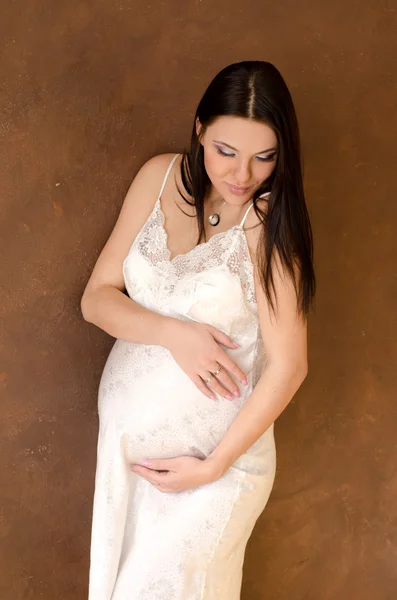 Beautiful pregnant woman in a negligee dress — Stock Photo, Image