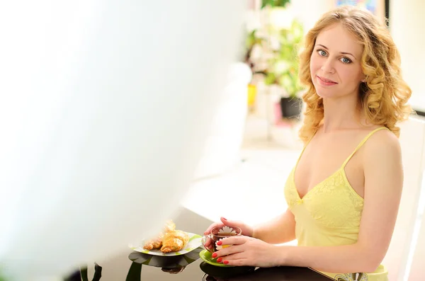 Jeune femme souriante à table avec petit déjeuner — Photo