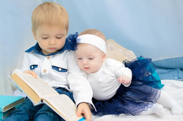 Bror och syster läser bok — Stockfoto