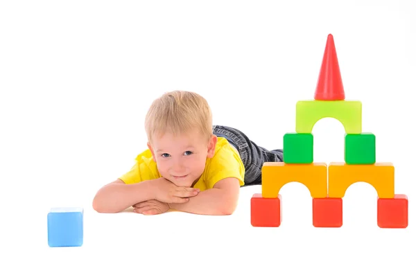 Niño acostado cerca de juguete construcción de cubos de colores — Foto de Stock