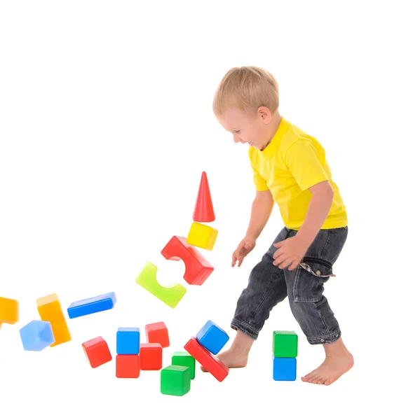 Menino destrói prédio de brinquedos de cubos coloridos — Fotografia de Stock