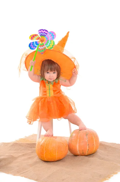 Little girl in orange costume with pumpkins — Stock Photo, Image