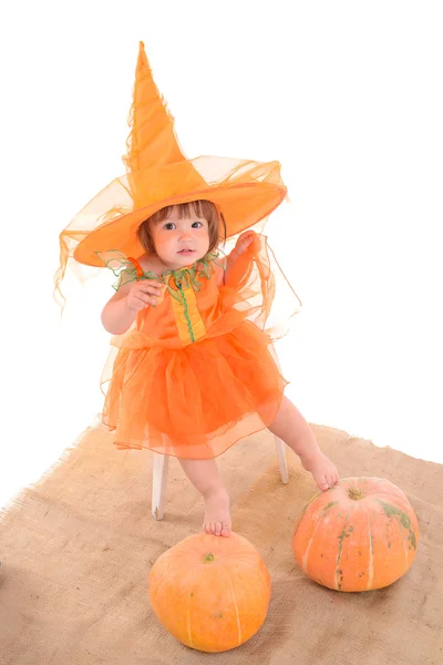 Little girl in orange costume with pumpkins — Stock Photo, Image