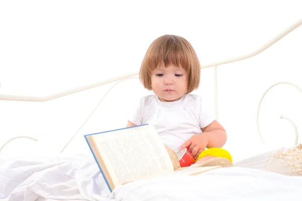 Baby girl sitting on white bed — Stock Photo, Image