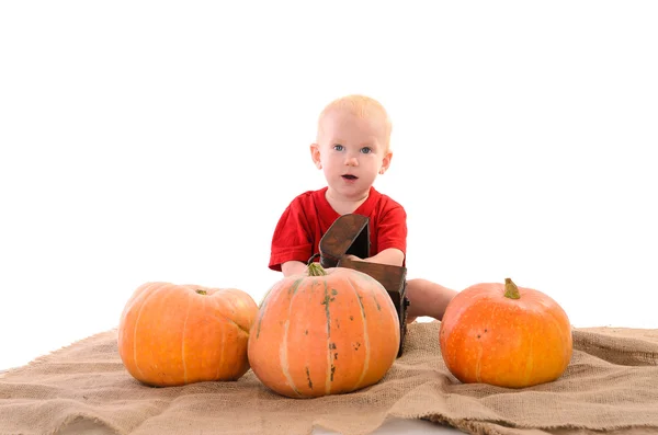 Kind mit orangefarbenen Kürbissen auf Sacktuch — Stockfoto