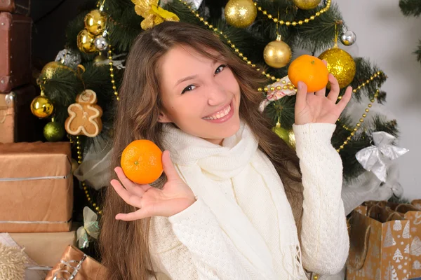 Zabawna dziewczyna z mandarynki w Boże Narodzenie wnętrza — Zdjęcie stockowe