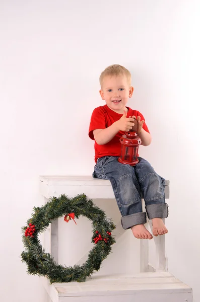 Petit garçon près de couronne de Noël — Photo