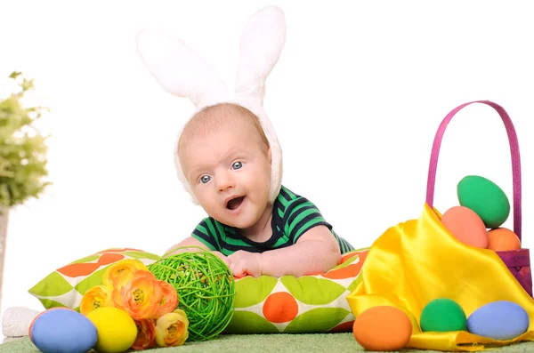 Baby with easter colored eggs — Stock Photo, Image