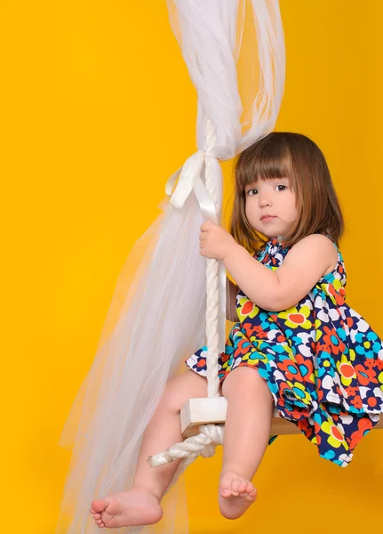 Little girl sitting on the Swings — Stock Photo, Image