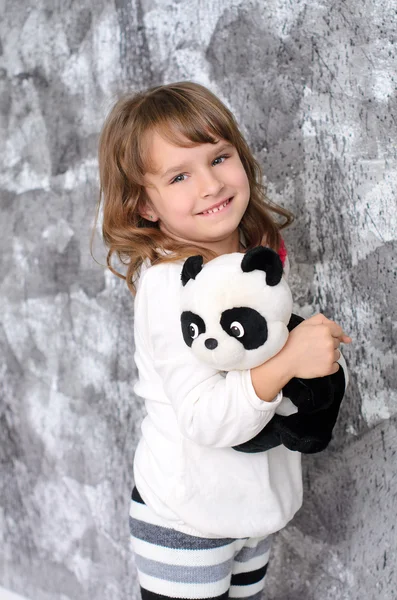Dziewczynka z zabawki panda pomieszczeniu — Zdjęcie stockowe