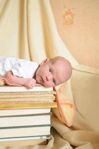 Baby liggend op stapel boeken — Stockfoto