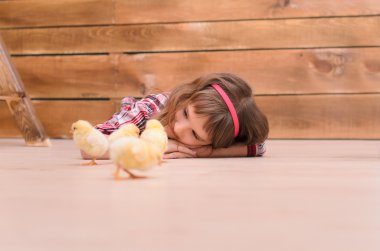 Yerde yatarken ve tavuklar için izlerken kız