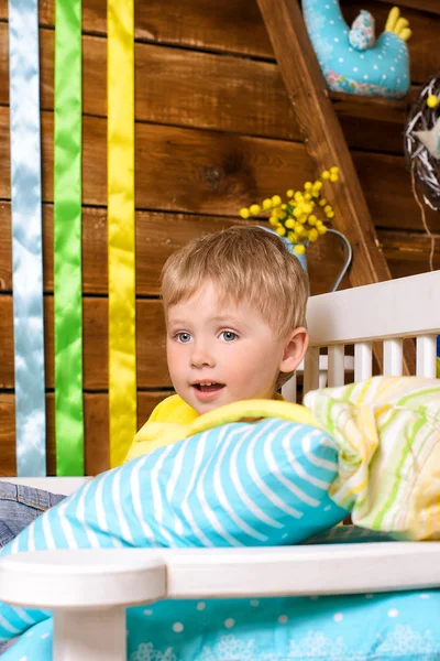 Kleine jongen op Bank met kussens binnenshuis — Stockfoto