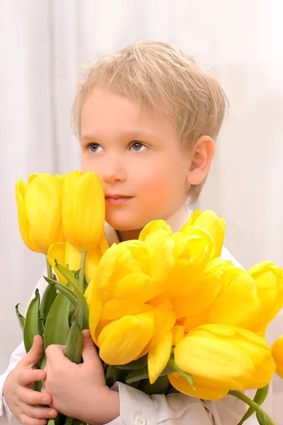 Garçon avec des tulipes jaunes — Photo