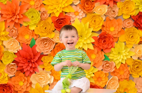 Laughing boy on flowers background — Stock Photo, Image