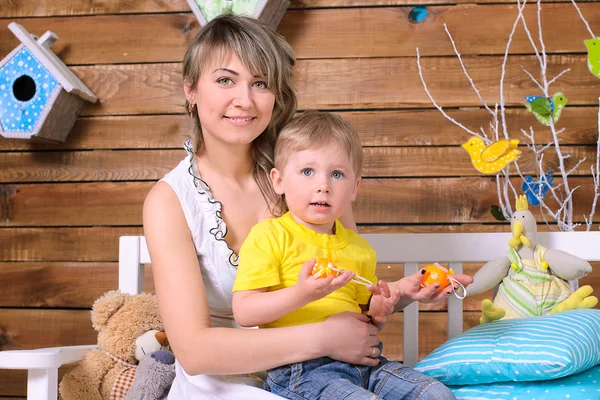 Madre e hijo pequeño sentados en el banco en el interior — Foto de Stock