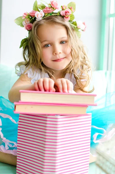 Little girl covered with wreath and books — Stock Photo, Image
