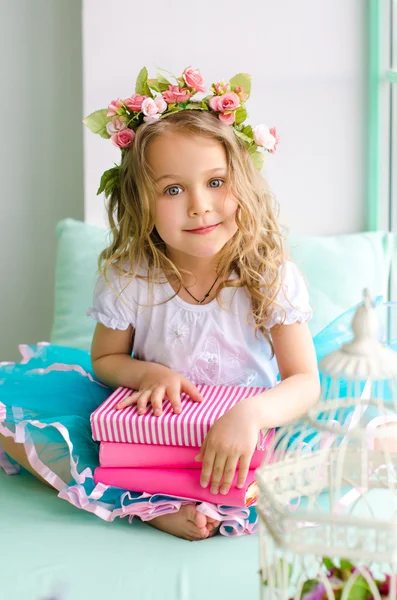 Little girl covered with wreath and books — Stock Photo, Image