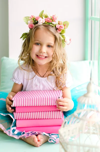 Petite fille avec couronne et pile de livres — Photo