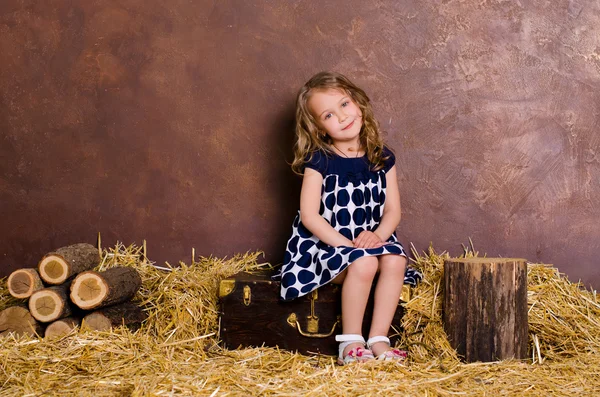 Bambina seduta sulla valigia in stile retrò — Foto Stock